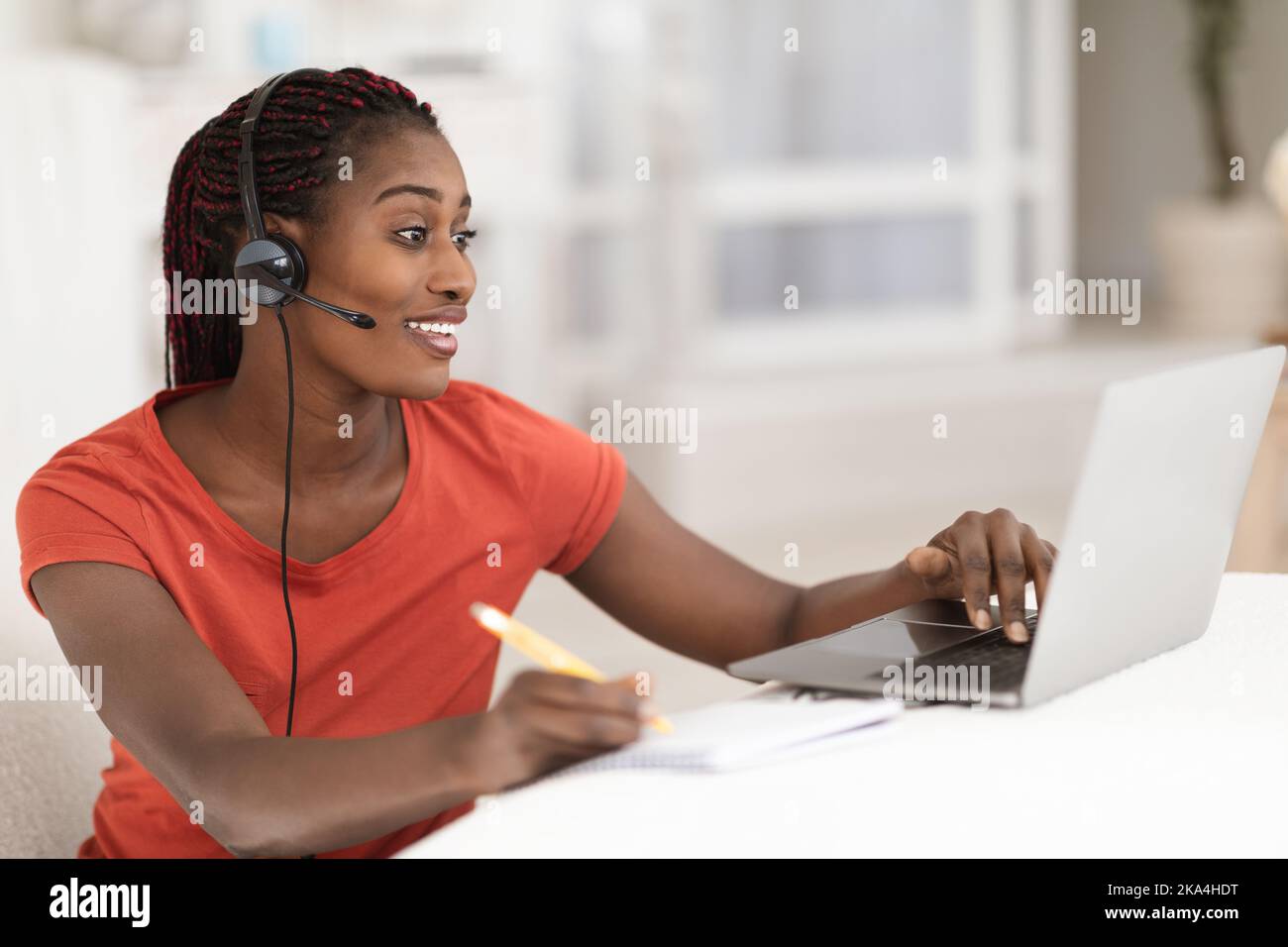 Apprendimento a distanza. Black Woman in Headset Study online con il notebook a casa Foto Stock