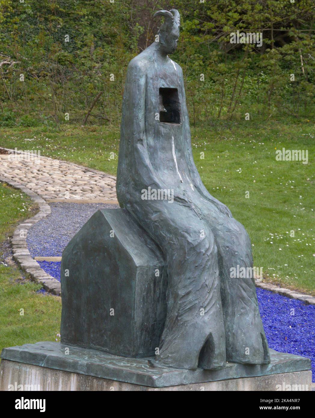 Statua del Diavolo del Baphomet con Campana e percorso colorato sullo sfondo Blu Verde Foto Stock