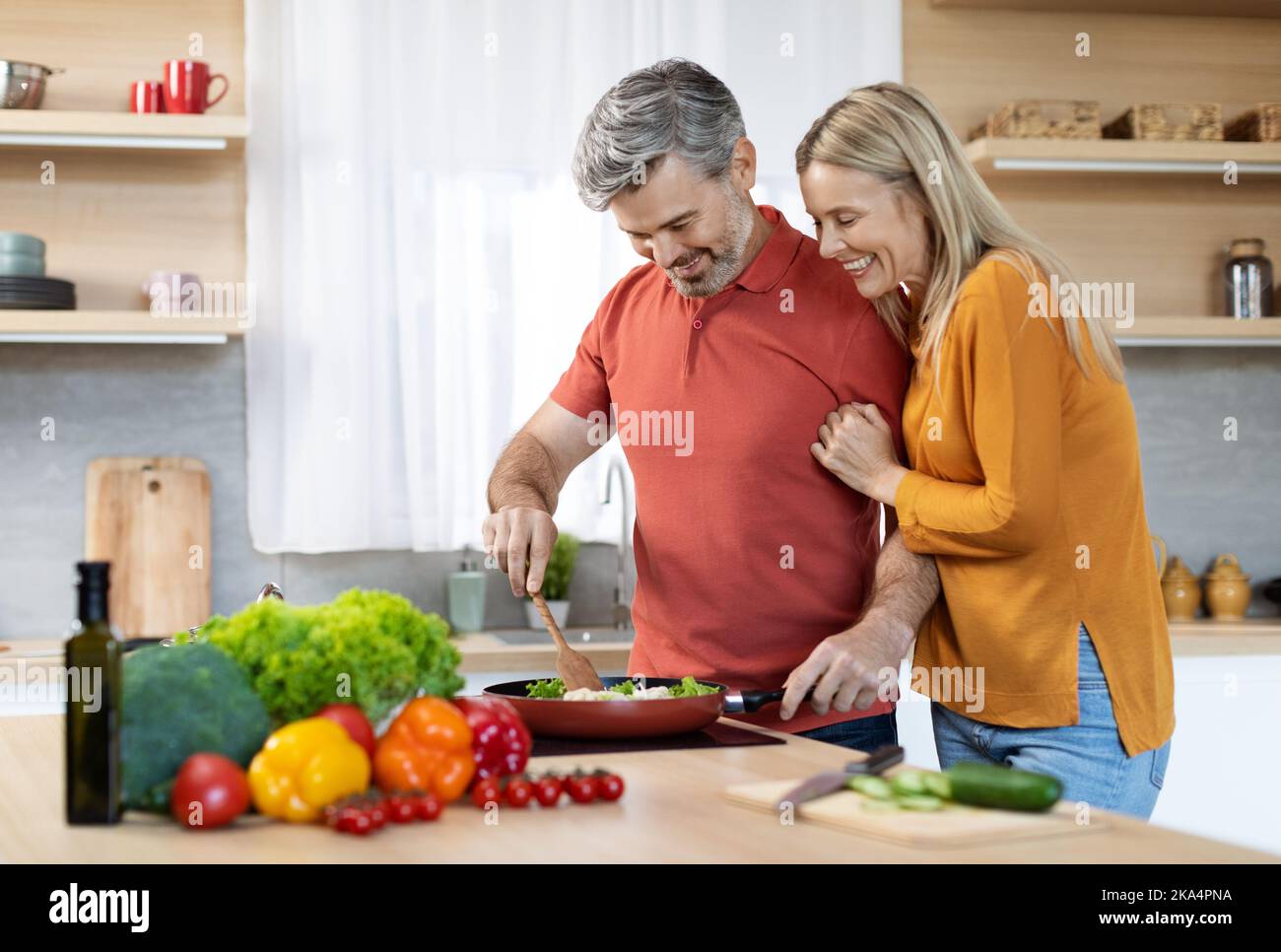Amare marito di mezza età cucinare per la sua bella moglie Foto Stock