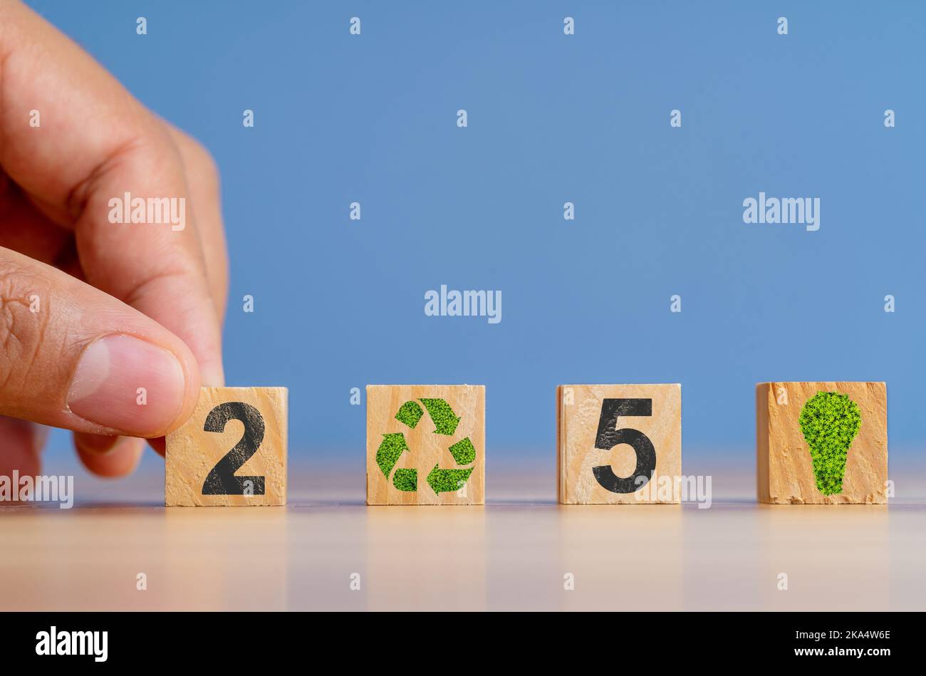 Tenere a mano i blocchi di legno con 2050 numeri scherzati come un simbolo dell'obiettivo netto di emissione di carbonio zero. Concetto di atmosfera senza carbonio. Foto Stock