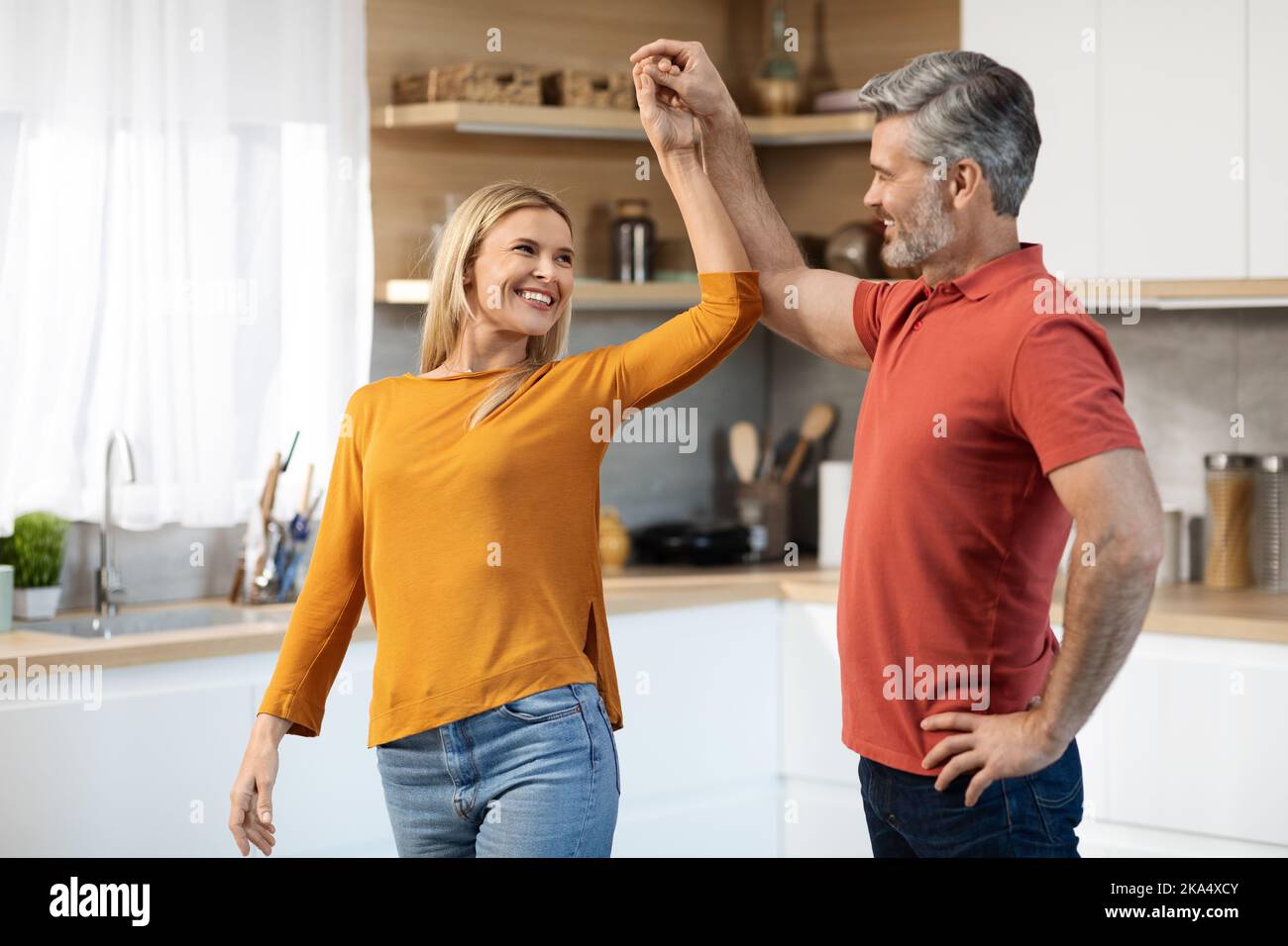 Splendidi sposi di mezza età che ballano insieme in cucina Foto Stock
