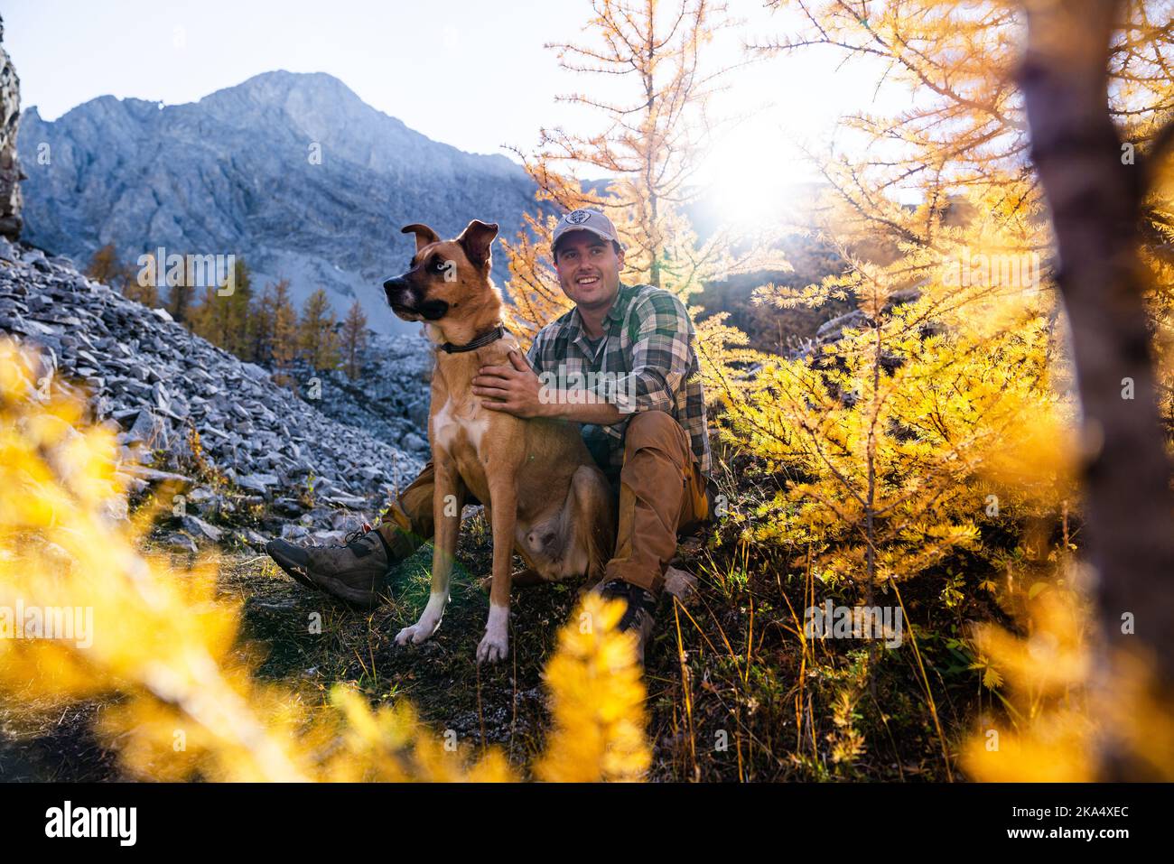 Uomo con il suo migliore amico su escursione al tramonto Foto Stock