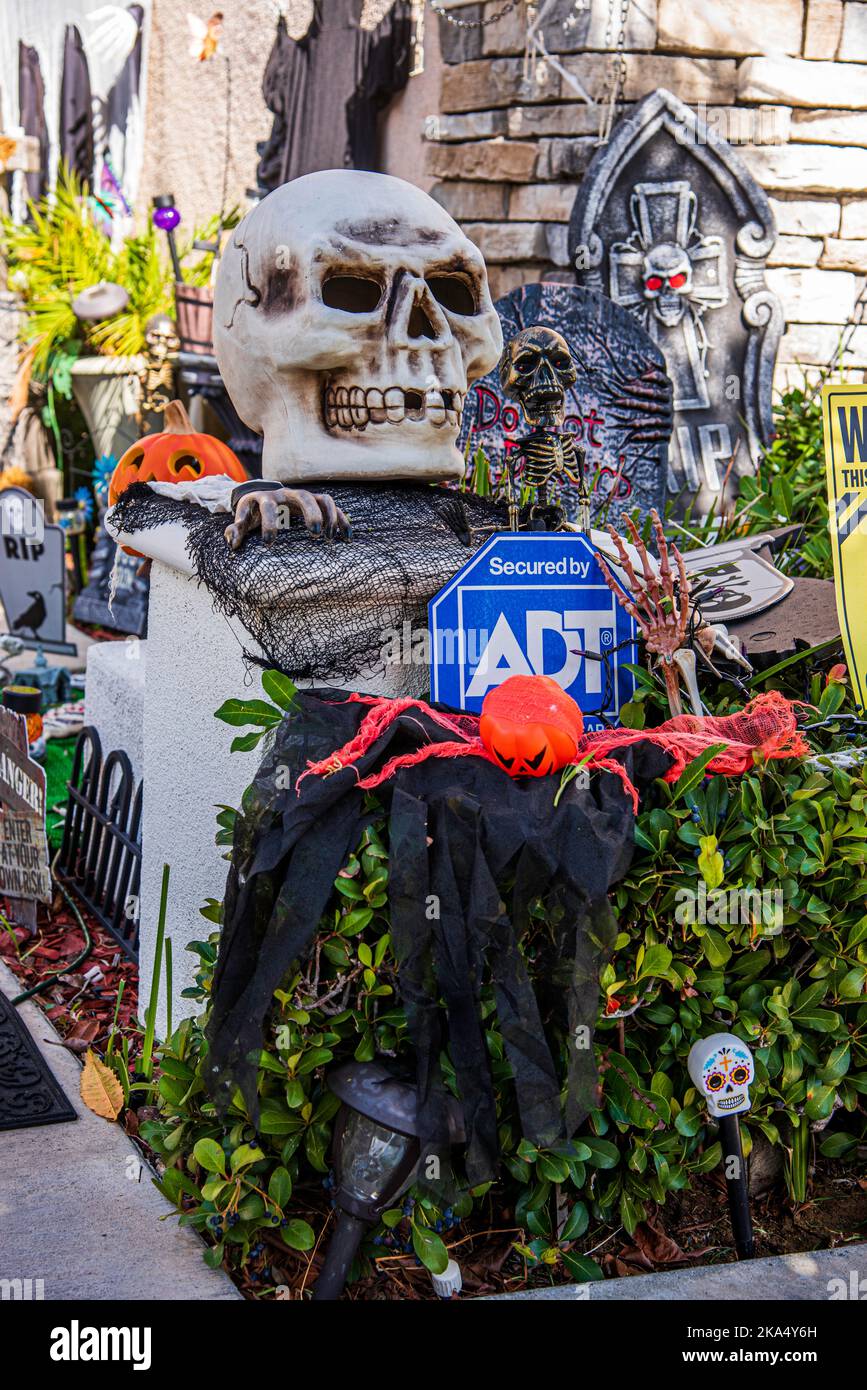 Le decorazioni di Halloween spaventose sono sparse dappertutto il cortile anteriore di una casa suburbana. Foto Stock