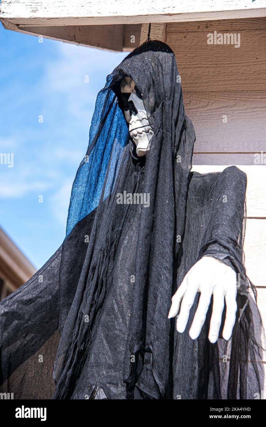 Uno scheletro vestito con un abito nero / felpa con cappuccio, decorazione di Halloween. Foto Stock