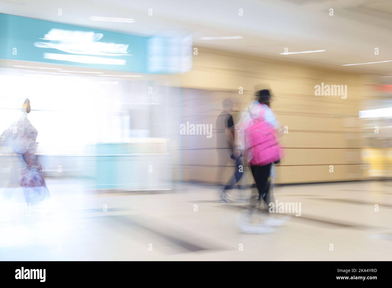 Una donna in viaggio sfocata con una valigia Foto Stock