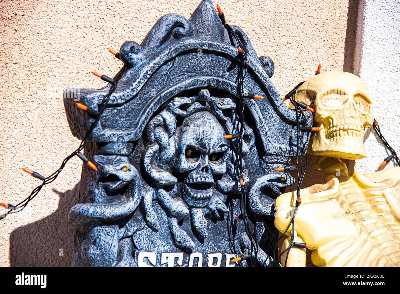 Un cranio spaventoso circondato da serpenti e scheletro decorazioni di Halloween. Foto Stock