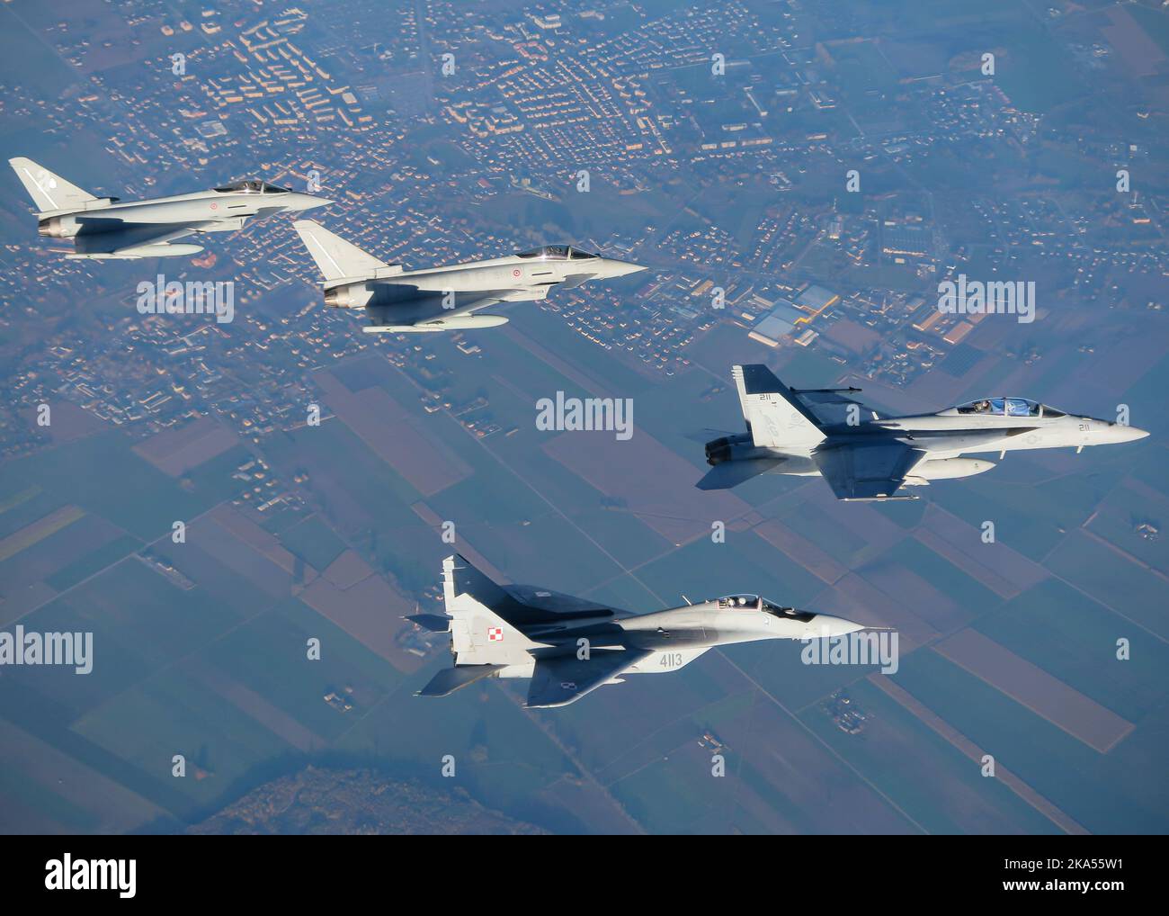221027-N-N0777-1013 POLONIA (OTT 27, 2022) i marinai assegnati allo Strike Fighter Squadron (VFA) 103 mostrano una bandiera NATO nell'abitacolo di un F/A-18F Super Hornet, frontale, vola in formazione con, da sinistra, due aerei francesi Eurofighter e un MIG-29 polacco durante l'attività di vigilanza guidata dalla NATO Neptune Strike 22,2 (NEST 22,2), 27 ottobre 2022. NEST 22,2 è la naturale evoluzione della capacità della NATO di integrare le capacità di guerra marittima di alto livello di un gruppo di sciopero del vettore per sostenere la difesa dell'alleanza in Europa. (STATI UNITI Foto di cortesia Navy) Foto Stock