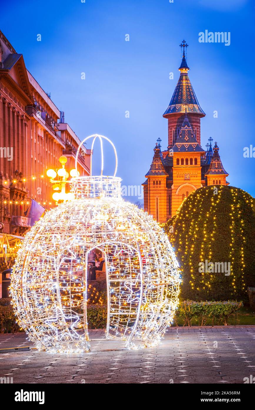 Timisoara, Romania. Festa del mercato di Natale in Piazza della Vittoria e Cattedrale. Scena notturna, decorazioni natalizie. Foto Stock