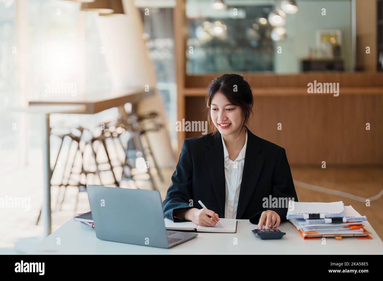 Ritratto di una donna d'affari asiatica che lavora con un sorriso felice in ufficio Foto Stock