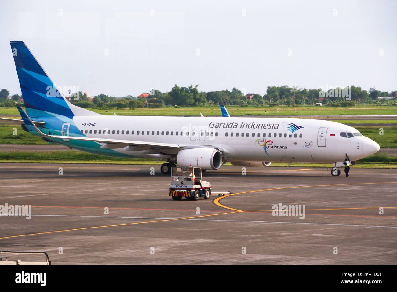 Vista dell'aereo di linea di Garuda Indonesia sulla pista dell'aeroporto internazionale di Juanda con nuvole sullo sfondo blu del cielo. Foto Stock