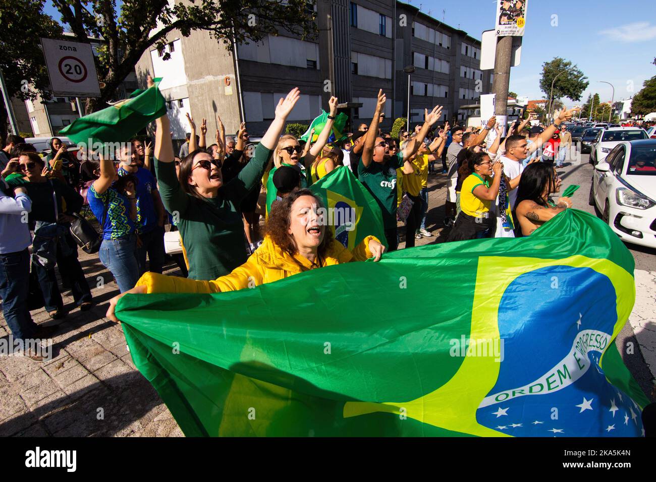 Porto, Portogallo. 30th Ott 2022. Un piccolo gruppo di sostenitori di Bolsonaro dimostra con una bandiera brasiliana davanti ai sostenitori di Lula, durante il rally elettorale a Porto. Migliaia di brasiliani votano nella città di Porto, in Portogallo, in un'atmosfera effusiva. Nonostante la stragrande maggioranza dei sostenitori di Lula, erano necessari rinforzi di polizia per mantenere l'ordine. Credit: SOPA Images Limited/Alamy Live News Foto Stock