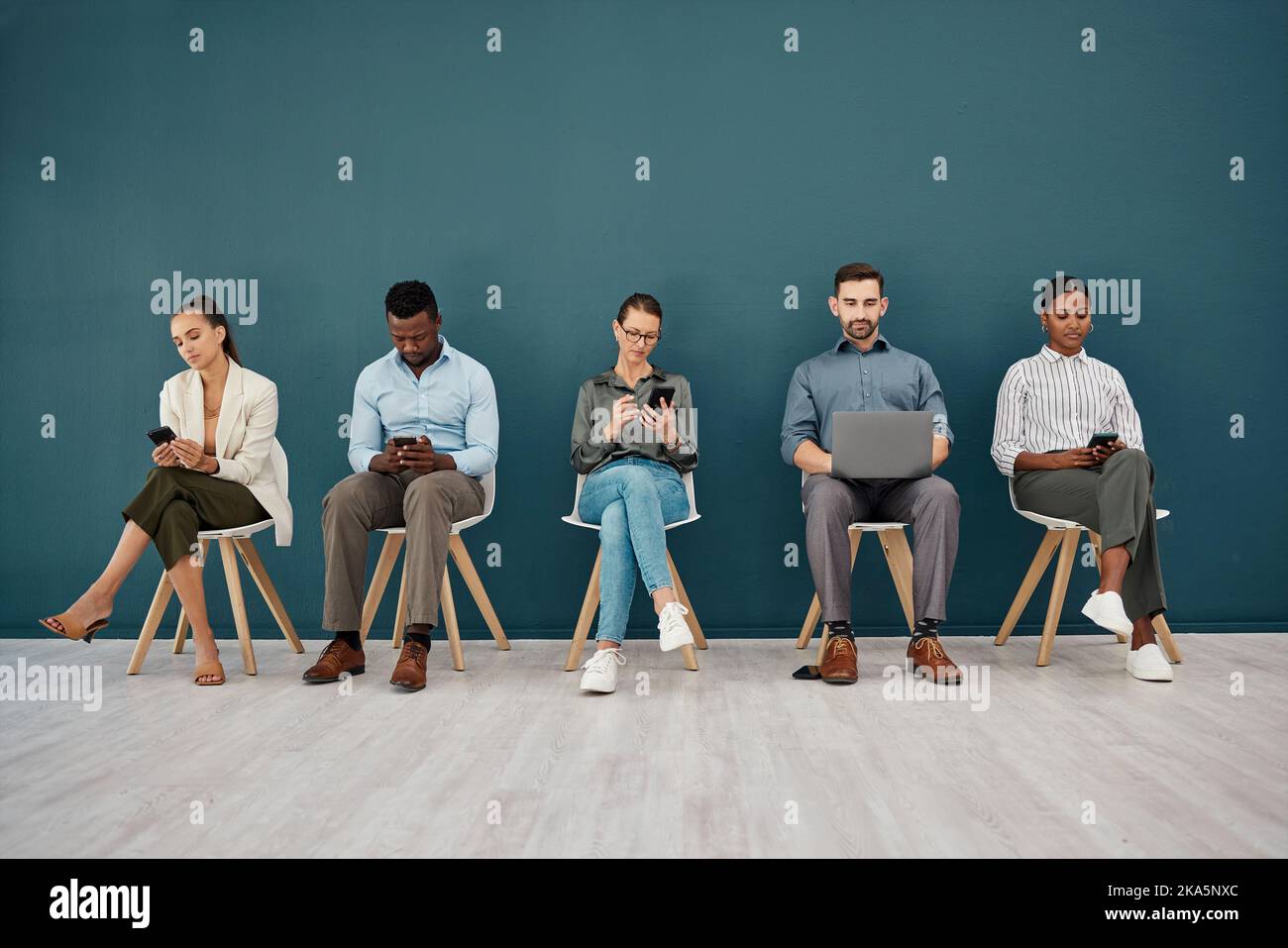 Reclutamento, telefono e laptop fila di sedie nel corridoio di spazio di lavoro in attesa con mockup. Processo della coda di colloquio aziendale con connessione online Foto Stock