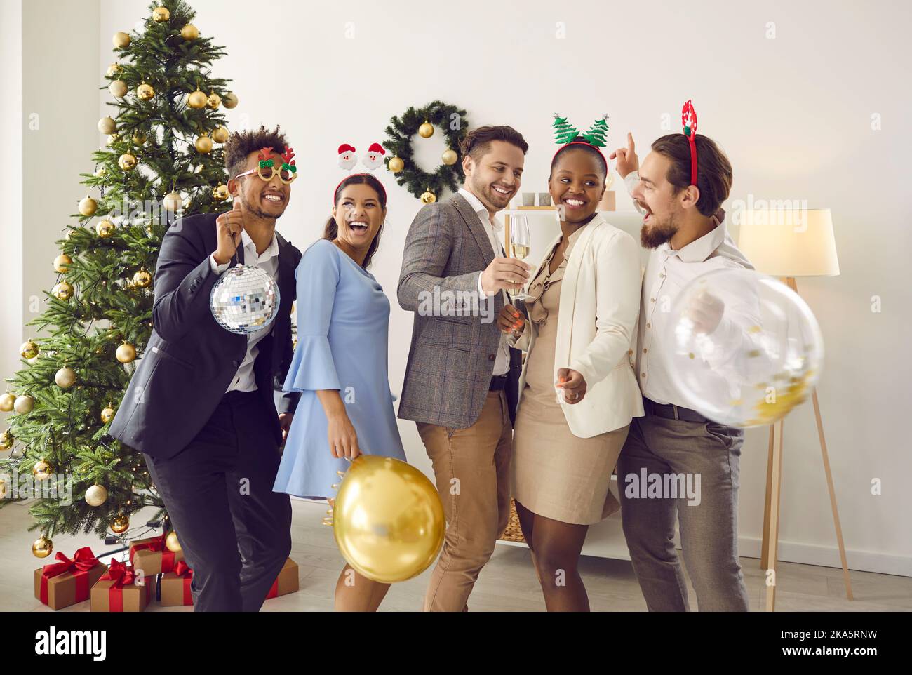 Gruppo di giovani amici multirazziali allegri che ballano e si divertono alla festa di Natale Foto Stock
