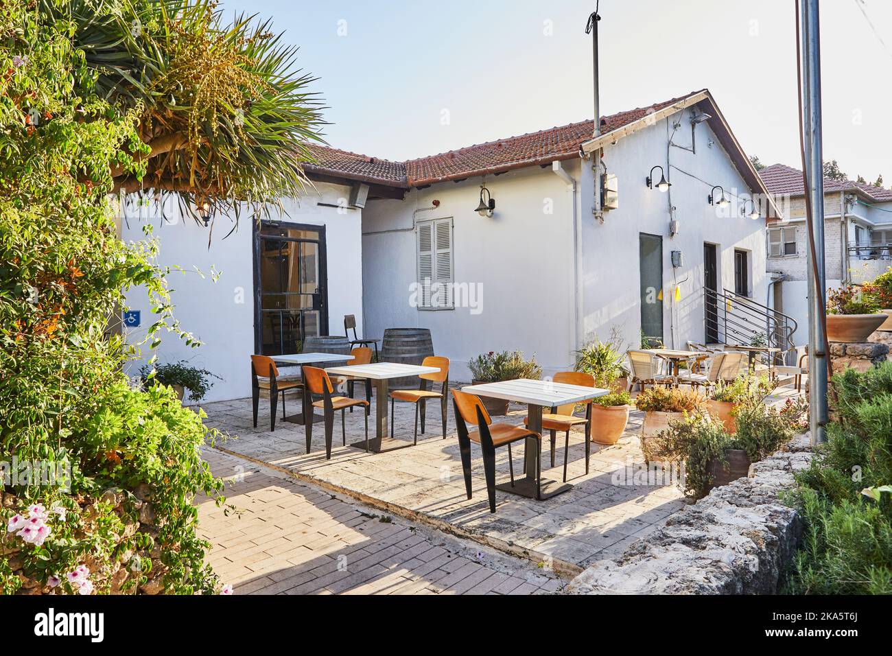 Caffè in una vecchia casa con tavoli ai raggi del sole Foto Stock