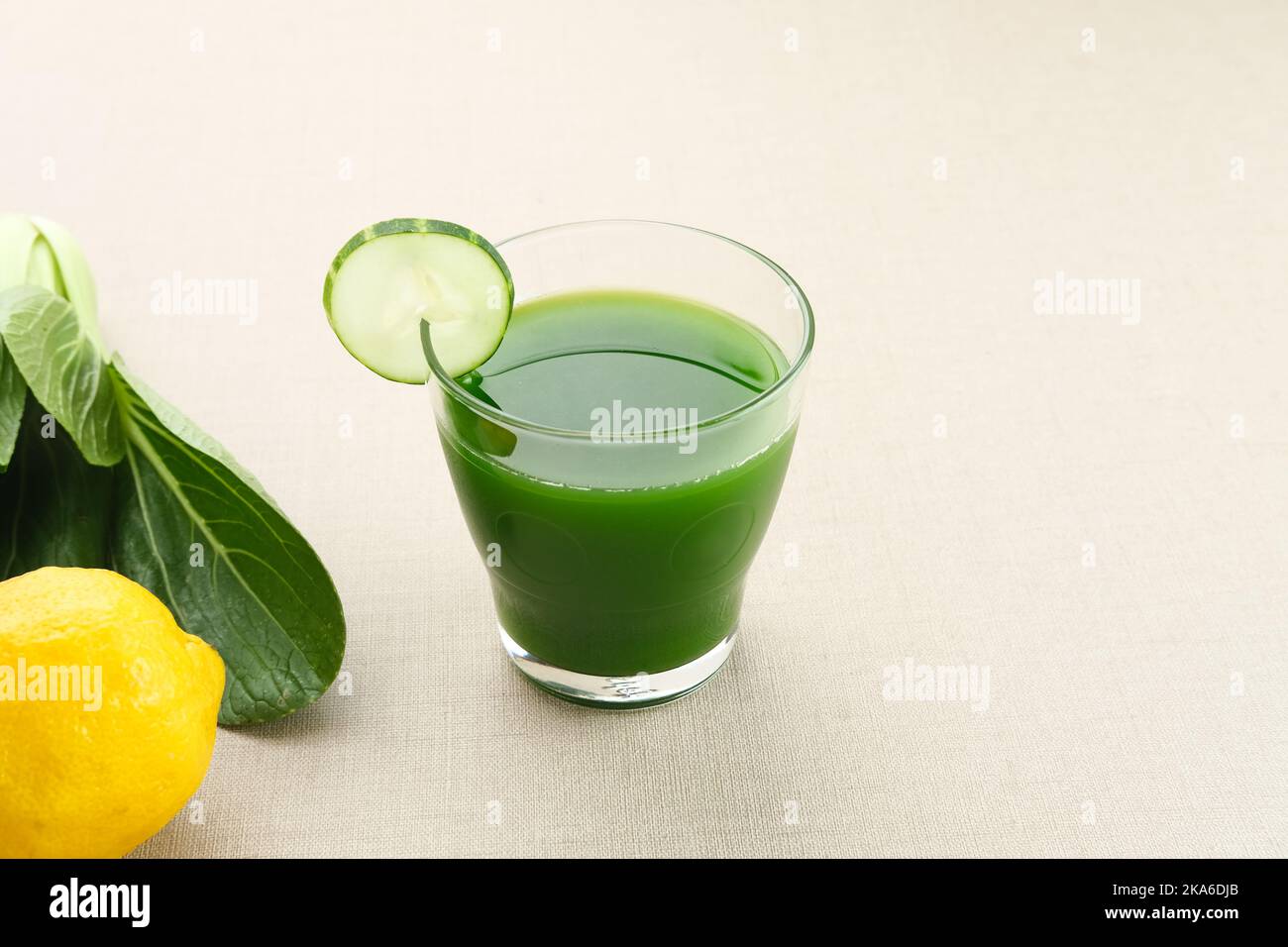 Un bicchiere di succo verde, fatto di pakcoy biologico, cetriolo e limone, molto buono per la salute. Succo spremuto a freddo Foto Stock