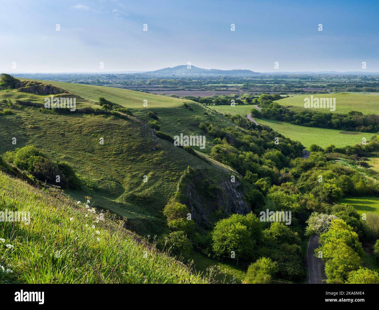 Il sito di interesse scientifico di Uphill Cliff con Brent Knoll Hill Beyond, North Somerset, Inghilterra. Foto Stock