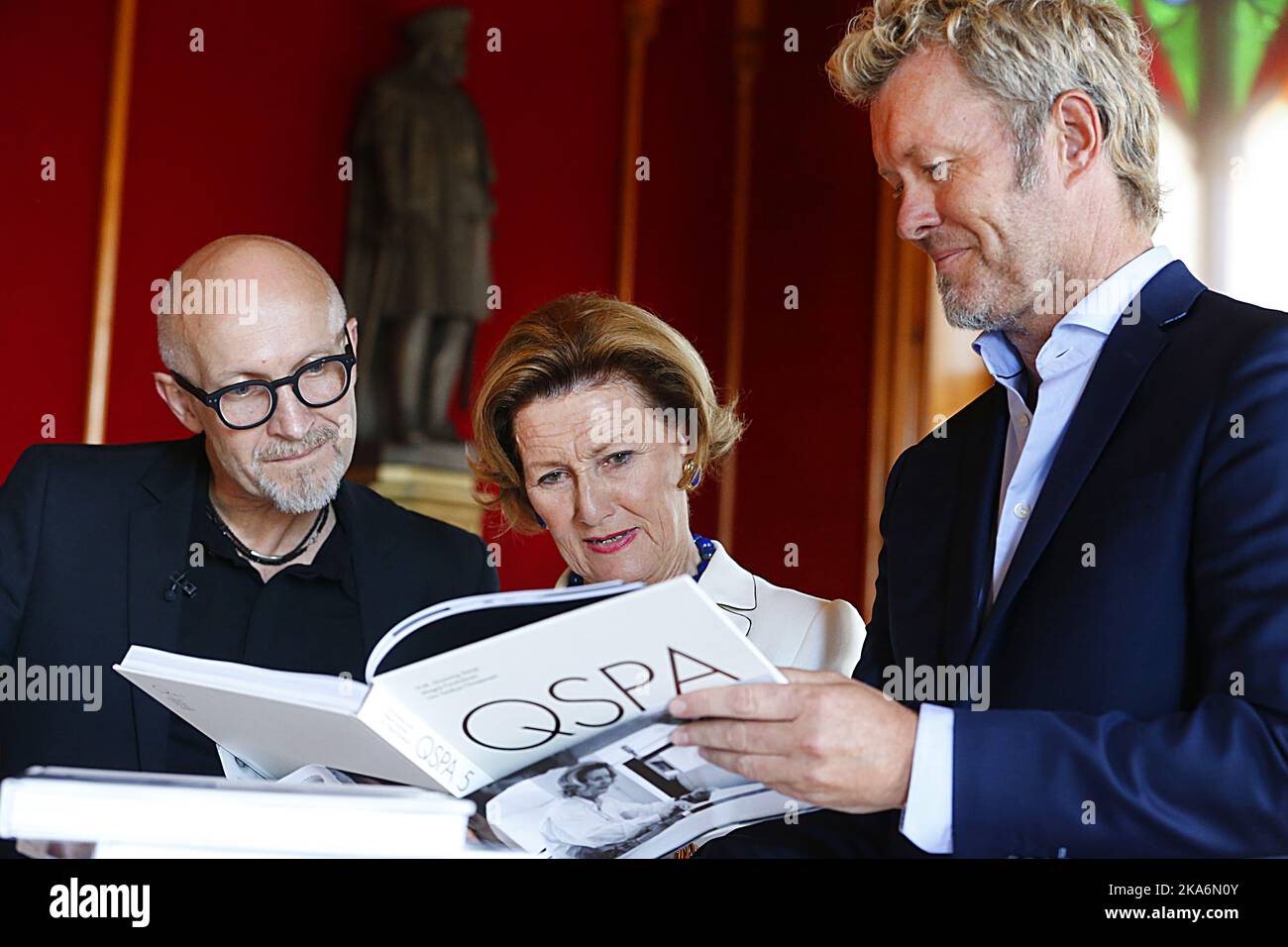 Bergen, Norvegia 20160823. Queen Sonja Print Award (QSPA) a Bergen. Immagini: Il libro 'Grafikkens vinger' (ali grafiche), che riguarda la collaborazione e le immagini della Regina Sonja (centro) e della Magne Furuholmen (a destra), e sulla Fondazione e il vincitore di quest'anno, Lars Saabye Christensen (occhiali) ha seguito i due artisti da vicino nel lavoro per diversi giorni. Foto: Rolf Oehman / Aftenposten / NTB scanpix Foto Stock