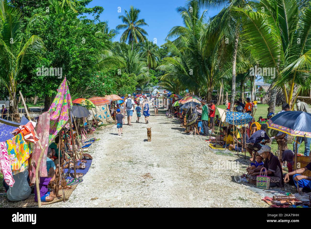 Gli abitanti del villaggio si allineano sulla strada vendendo artigianato e souvenir per visitare i passeggeri delle navi da crociera. Isola di Kiriwina Papua Nuova Guinea. Foto Stock