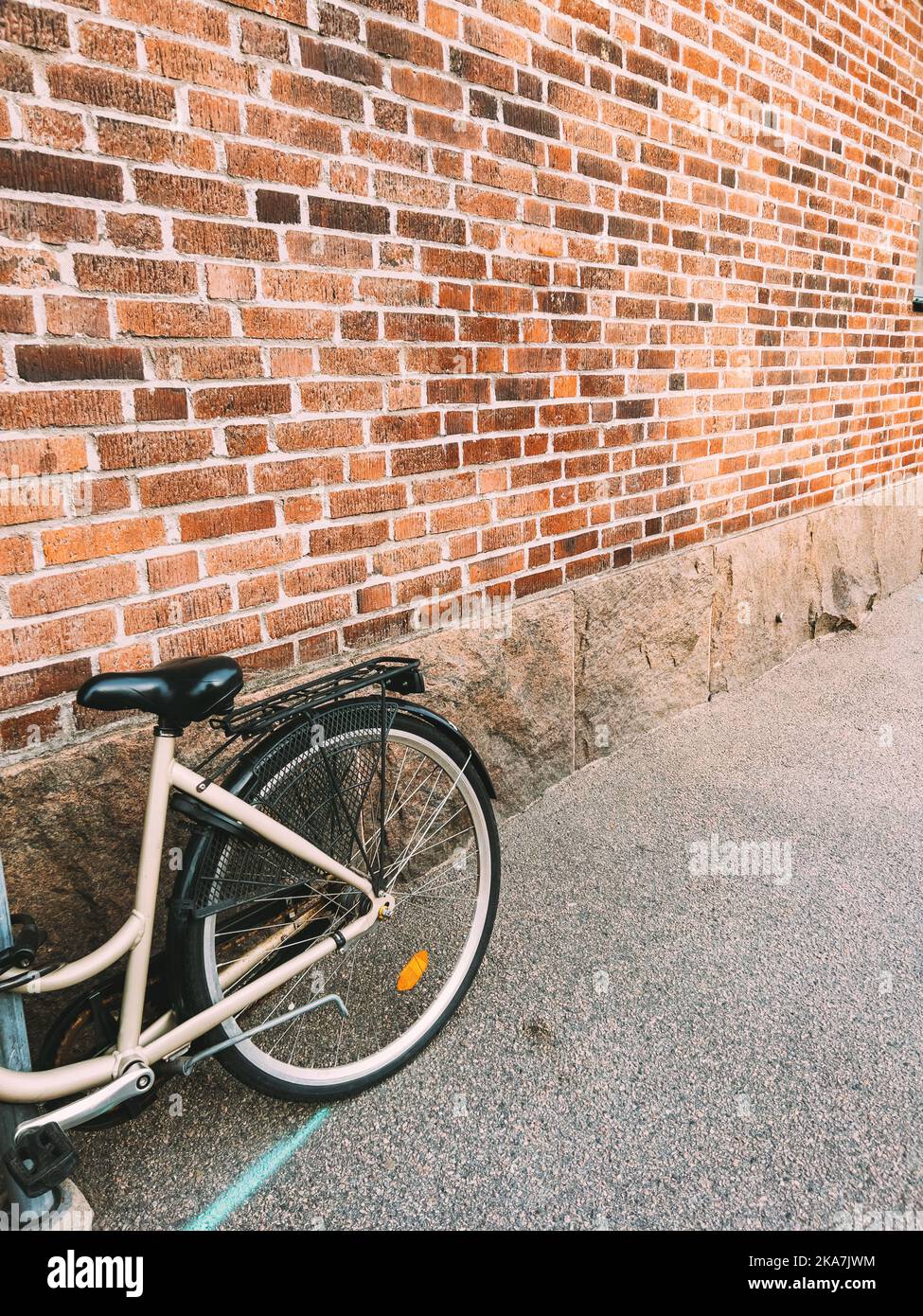 Bicicletta appoggiata contro il muro di mattoni vintage sulle strade di Halmstad in Svezia con spazio copia Foto Stock