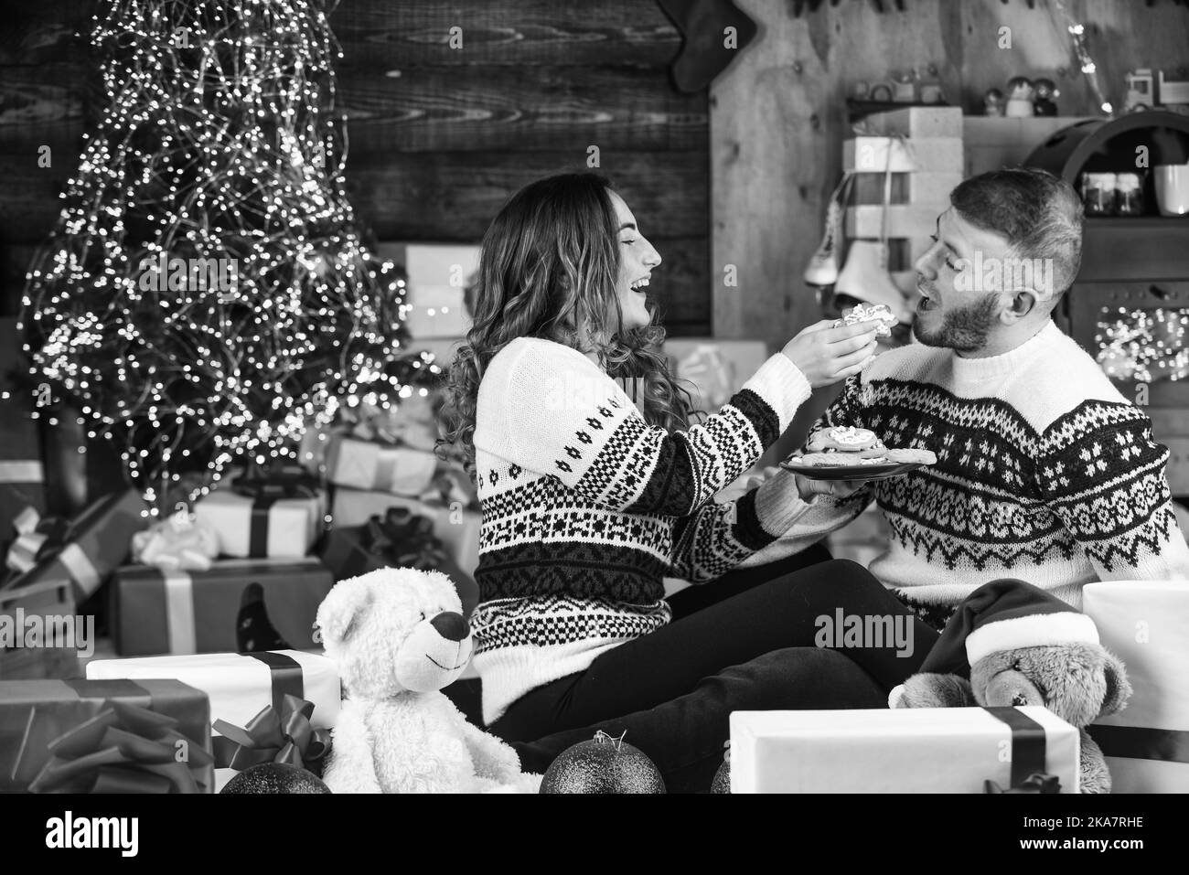 divertirsi. coppia innamorata divertirsi a casa. festeggiare le feste di natale con la coppia. amiamo le nostre tradizioni. uomo e donna felici mangiano biscotti natalizi. ho Foto Stock