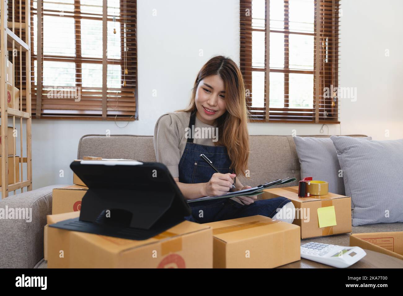 Donna asiatica freelancer pmi business shopping online lavorando con la scatola pacchi a casa - PMI business online e concetto di consegna Foto Stock
