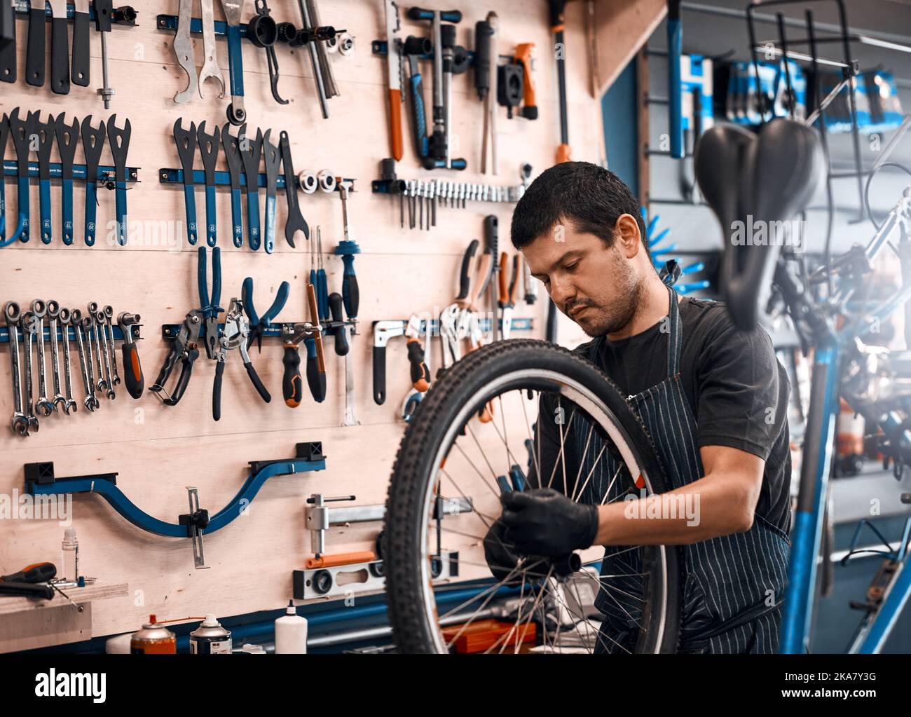 Egli sa di cosa hanno bisogno le biciclette, un uomo che lavora in un negozio di riparazione di biciclette. Foto Stock