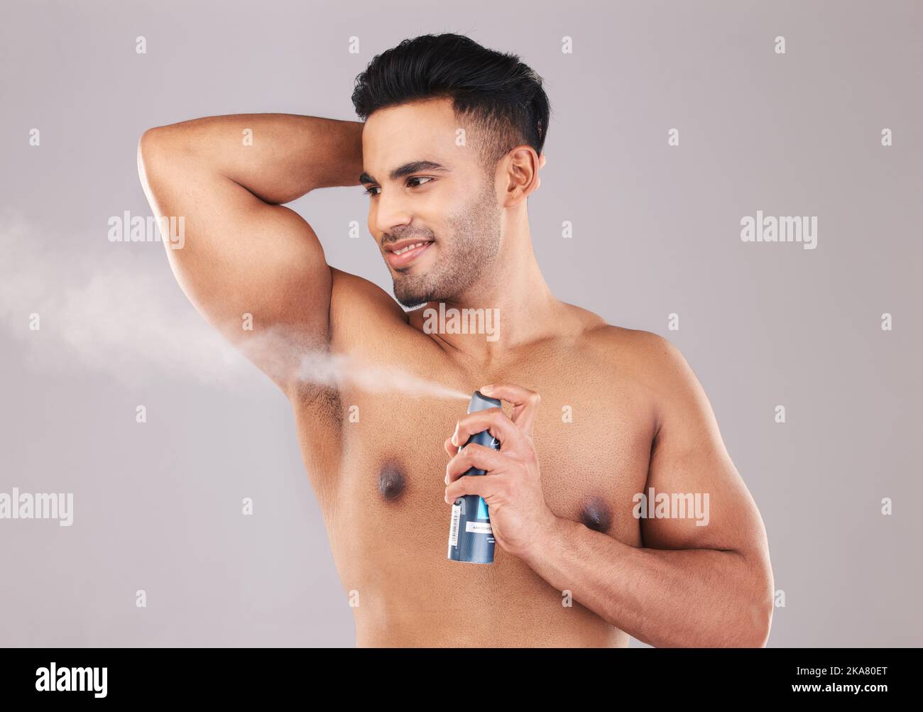 Deodorante, ascelle e spray per l'uomo in studio per l'igiene, il benessere e la cura di sé. Spruzzare, pulito e giovane modello dalla Colombia con fragranza con un Foto Stock