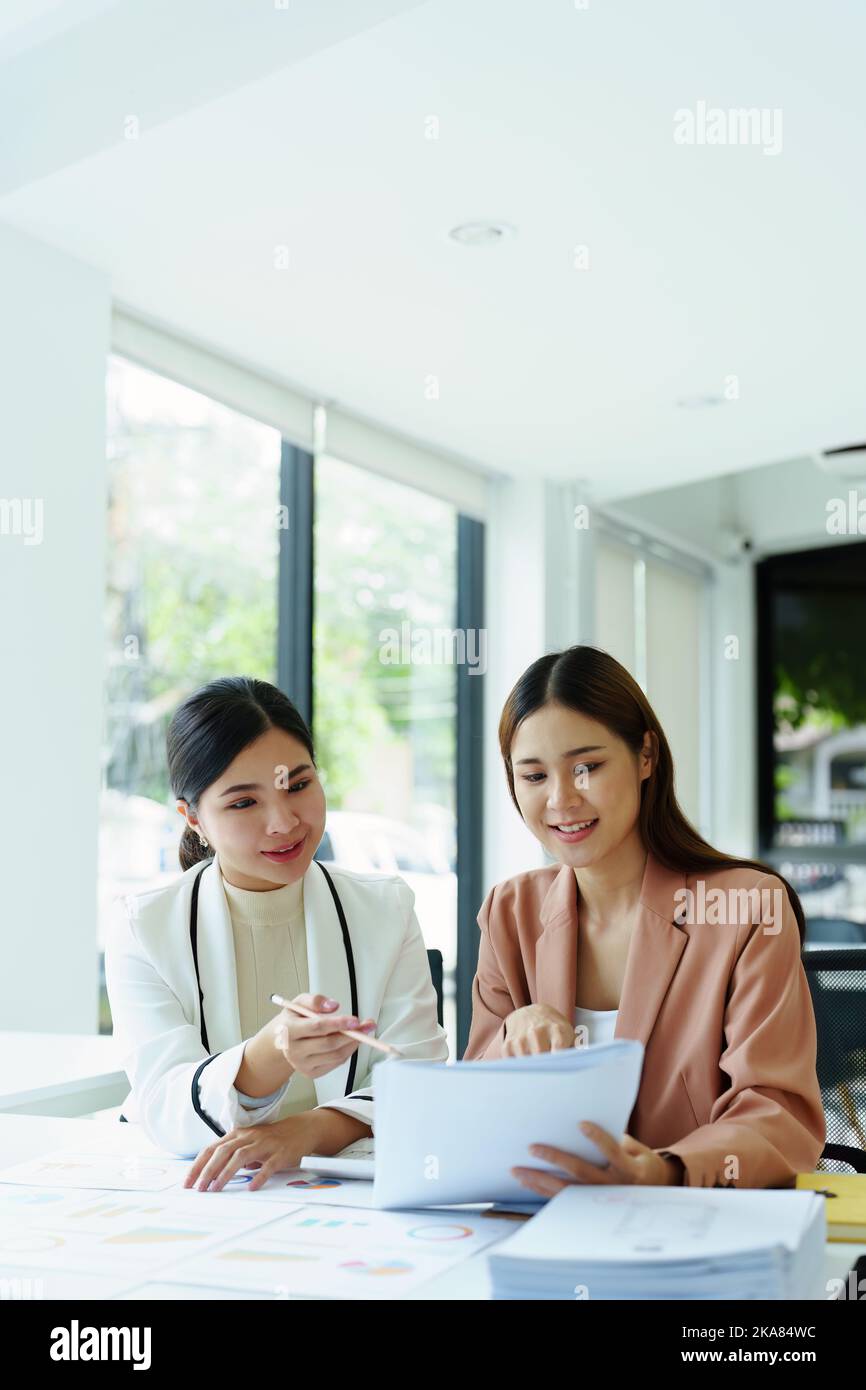 due imprenditrici asiatiche che utilizzano i documenti per analizzare i lavori. Foto Stock