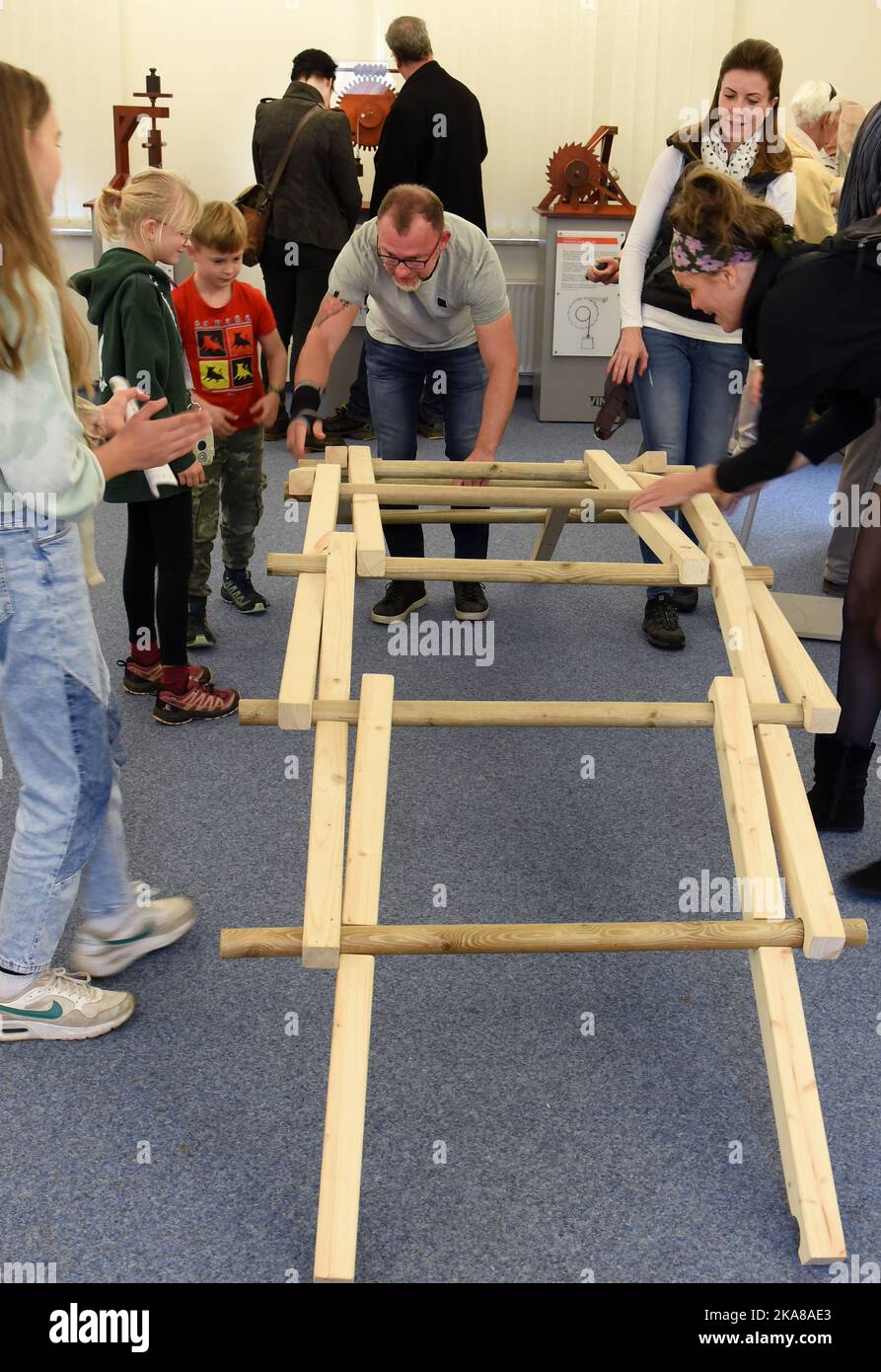 31 ottobre 2022, Sassonia, Grimma: Nella mostra "da Vinci 500 - Moving invenzioni" nel Wilhelm Ostwald Park, i visitatori riassemblano un modello di un ponte in legno autoportante, precedentemente crollato, di da Vinci (1452-1519). La mostra è uno dei 27 modelli 100 funzionali sviluppati, progettati e realizzati da studenti del Dipartimento di Ingegneria e Matematica dell'Università di Scienze applicate di Bielefeld sulla base di schizzi della matematica italiana. Fino a marzo 2023, i visitatori possono non solo visualizzare i modelli, ma anche provarli e comprendere i processi tecnici. Foto: Waltraud Gruditzsc Foto Stock