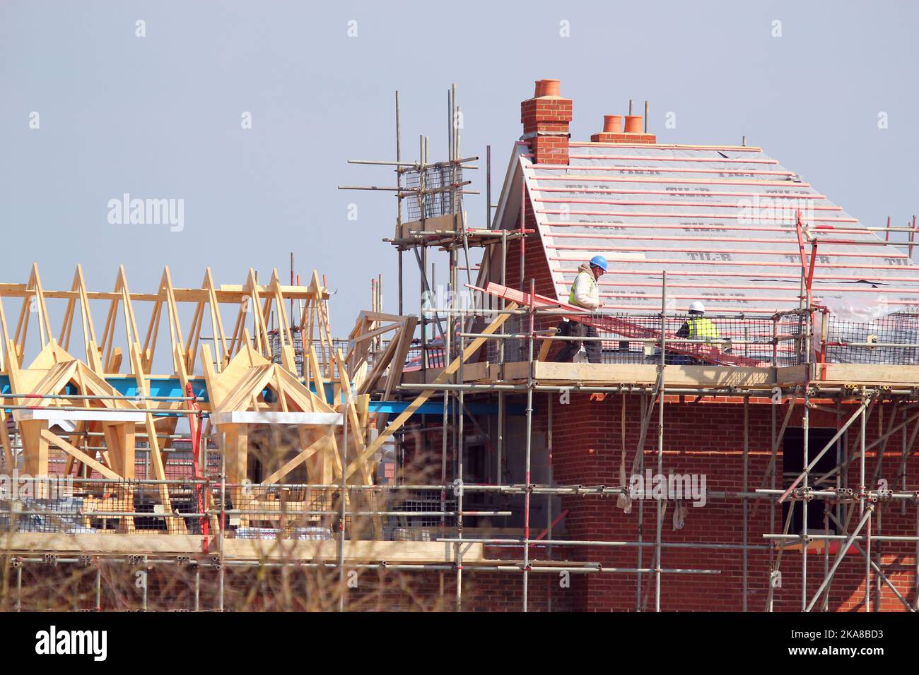 Operai di costruzione. Costruttori di impalcature erigere una nuova casa di costruzione. Foto Stock
