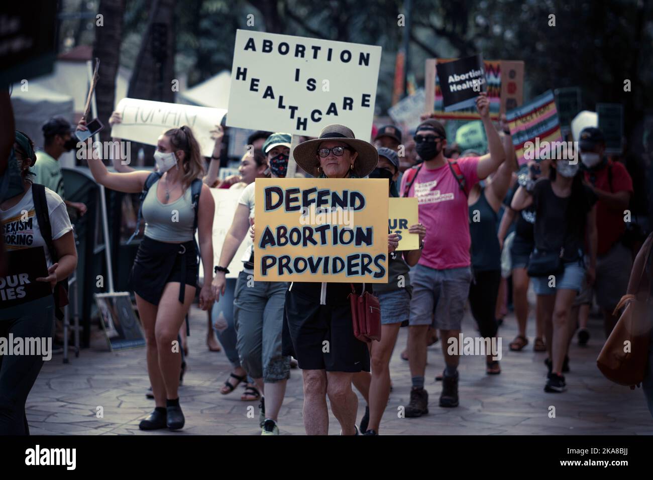 Una donna con un poster di 'difendere i fornitori di aborto' - Rally dei diritti umani a Waikiki Foto Stock