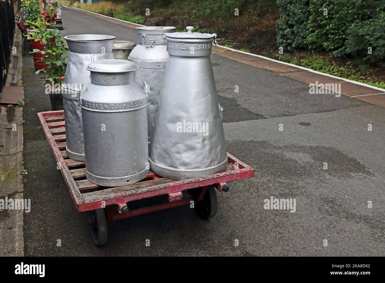 Vecchi churns di latte su carrello a mano, Ingrow West Station, Keighley & Worth Valley Railway Foto Stock