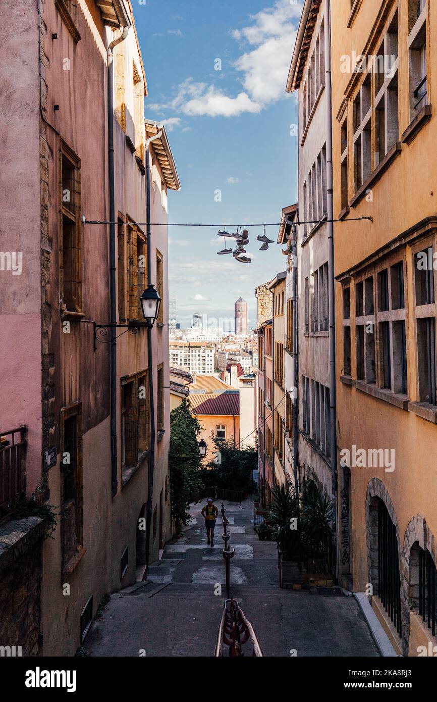 Un tiro verticale di scarpe appese su una strada stretta nella Vecchia Lione, la città vecchia di Lione Foto Stock