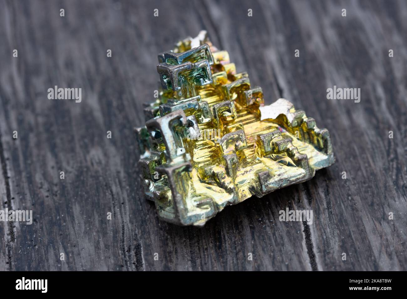 Un metallo fatto a mano, bismuto, con tonalità di verde e oro Foto Stock