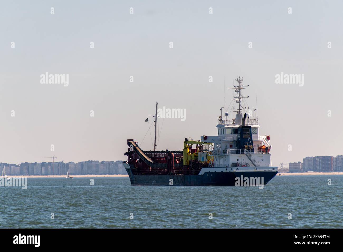 Una nave da dragaggio che naviga nel mare ondulato del Nord in Belgio Foto Stock