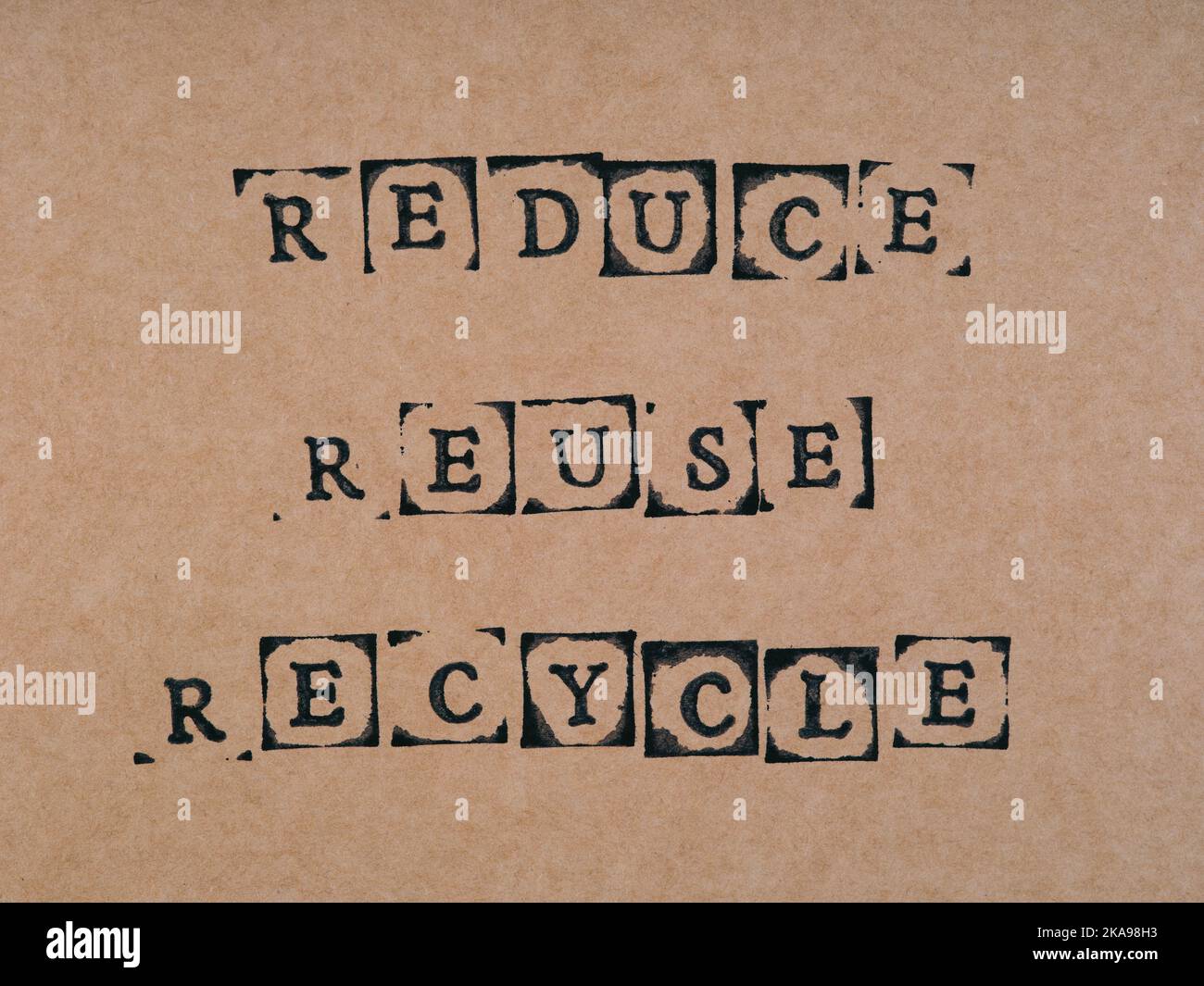 Un cartone con parole Riduci, Riusa, Recycle realizzato con francobolli alfabetici neri. Foto Stock
