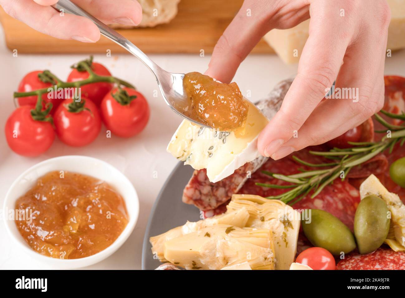 Donna che mangia antipasti italiani. Piatto di salumi con diversi tipi di salsicce e formaggi - salame, bresaola, prosuzzo, dorblu, parmigiano Foto Stock