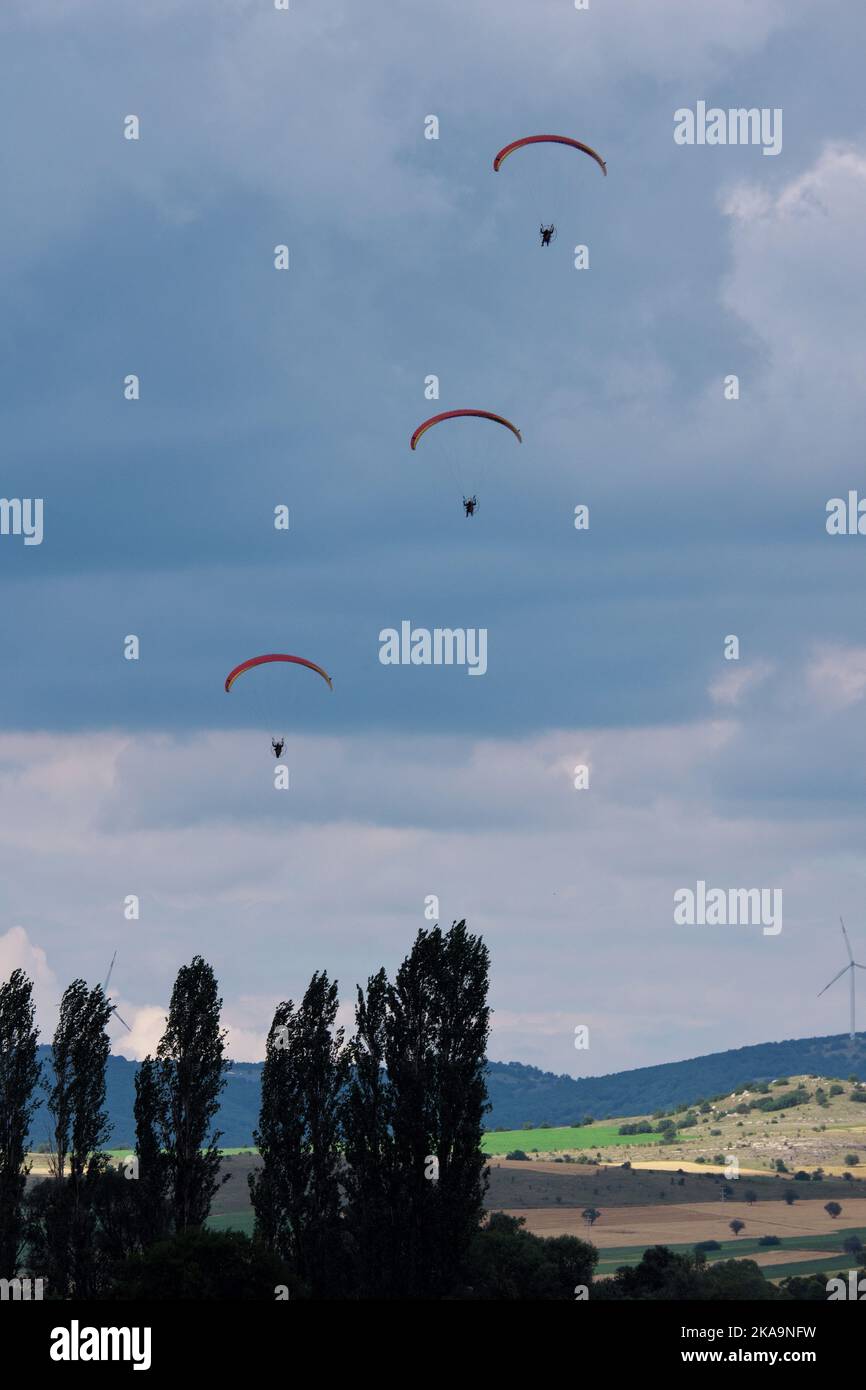 I paracadutisti si avvicinano al terreno. Nuvole, colline e alberi sullo sfondo Foto Stock