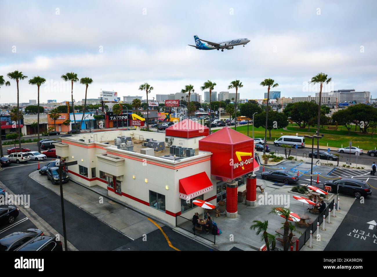 L'aereo Alaska Airlines sorvola il ristorante in-N-out Burger mentre atterra all'aeroporto internazionale di Los Angeles LAX Foto Stock