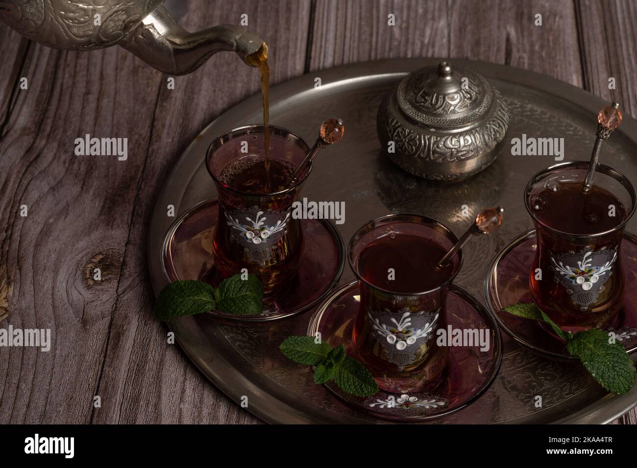 Serve tè moresco caldo su un vassoio con bicchieri e caraffa su un tavolo di legno Foto Stock