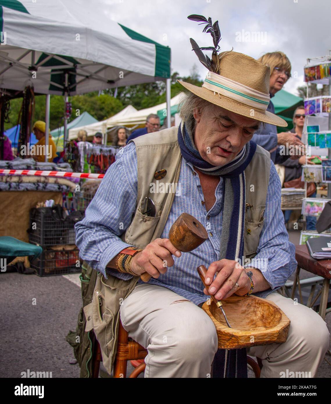 Poeta e autore Ian Bailey intagliando una ciotola di legno con uno scalpello. Foto Stock