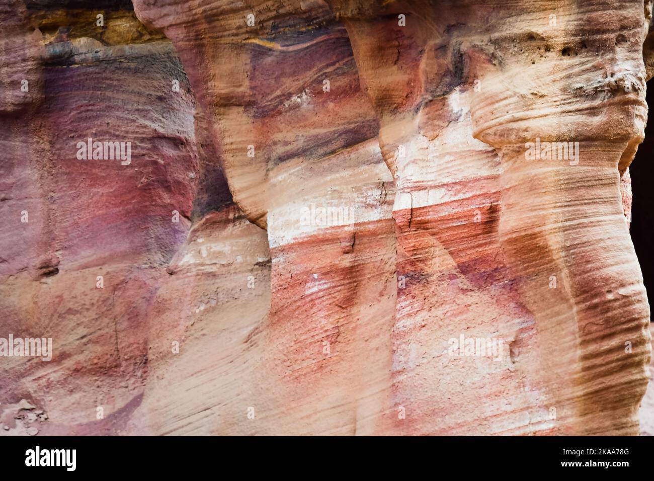 Bel colore texture rosa arancione rosso giallo bianco colore geologico formazioni rocciose nella città di Petra in Giordania Foto Stock