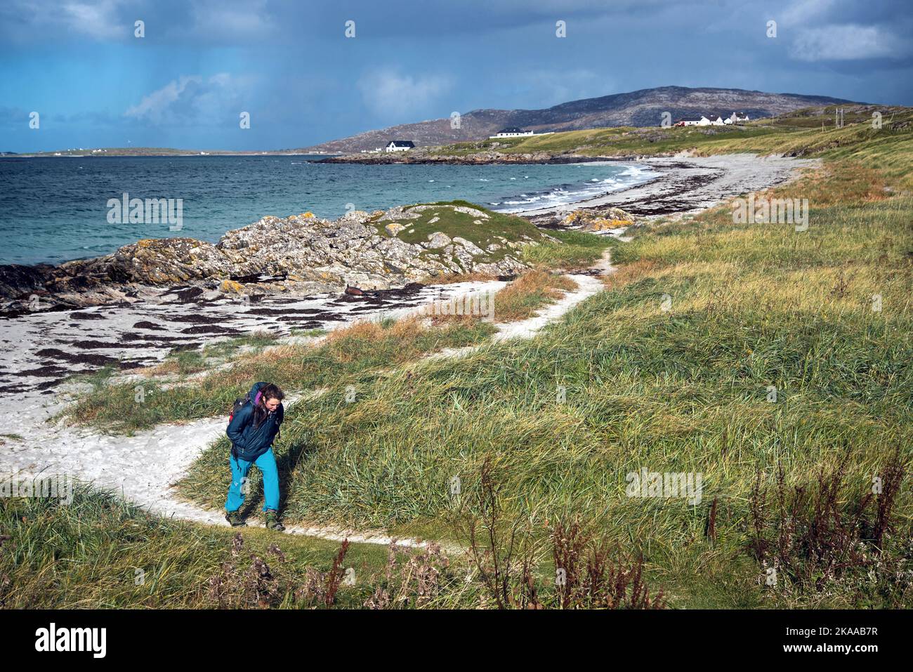 Giovane donna che camminava a Prince's Bay, la spiaggia era Bonnie Prince Charlie arrivato per la prima volta in Scozia, sull'isola di Eriskay, Ebridi esterne, Scozia. Foto Stock