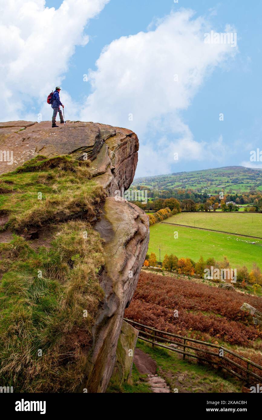 L'uomo in piedi sulla roccia affiora la pietra sospesa nella campagna del Cheshire a Danebridge Cheshire Foto Stock