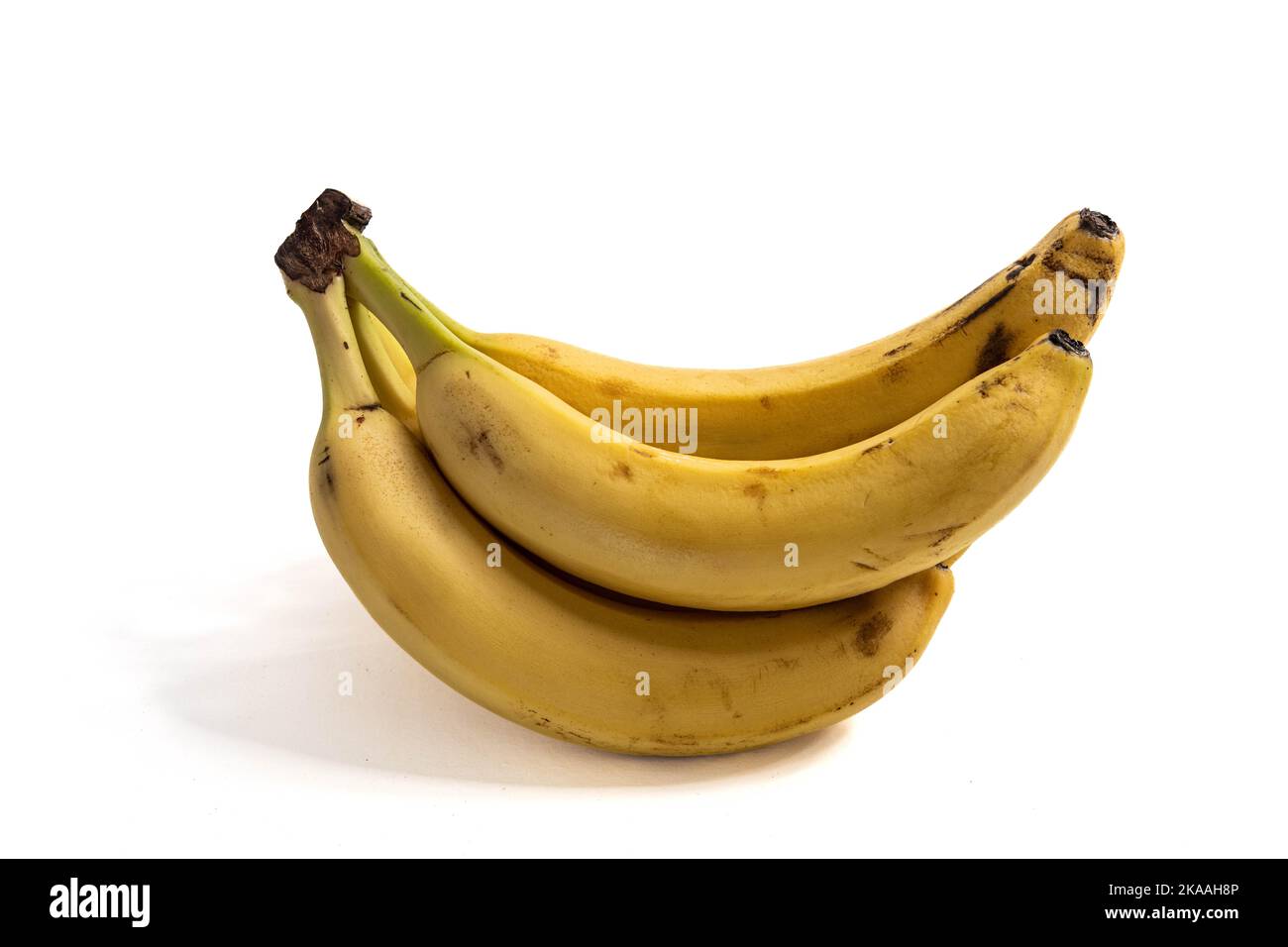 mazzetto di banane mature su una superficie bianca Foto Stock