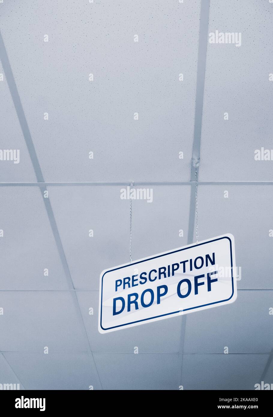 Semplice bianco e blu prescrizione drop-off segno appeso a un soffitto interno di una farmacia. Foto Stock