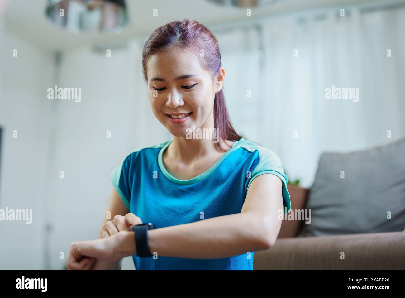 Sanità, monitoraggio della frequenza cardiaca, ritratto di bella donna asiatica utilizzando l'orologio intelligente per selezionare programmi di salute come yoga, cardio esercizi Foto Stock Sanità, monitoraggio della frequenza cardiaca, ritratto di bella donna asiatica utilizzando l'orologio intelligente per selezionare programmi di salute come yoga, cardio esercizi Foto Stock