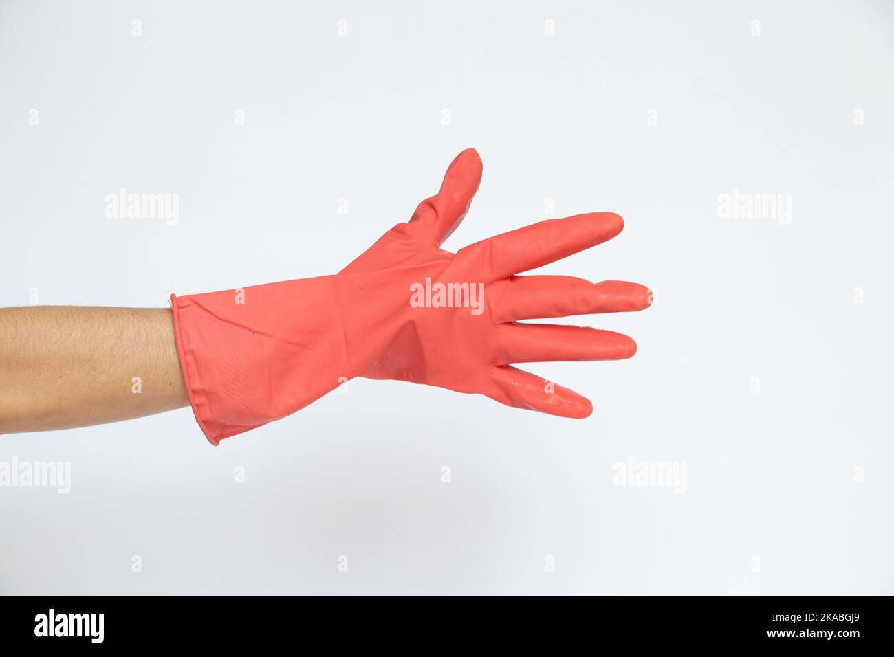 Mano femmina in un guanto da cucina rosa su sfondo bianco, lavori di casa, pulizia della casa Foto Stock