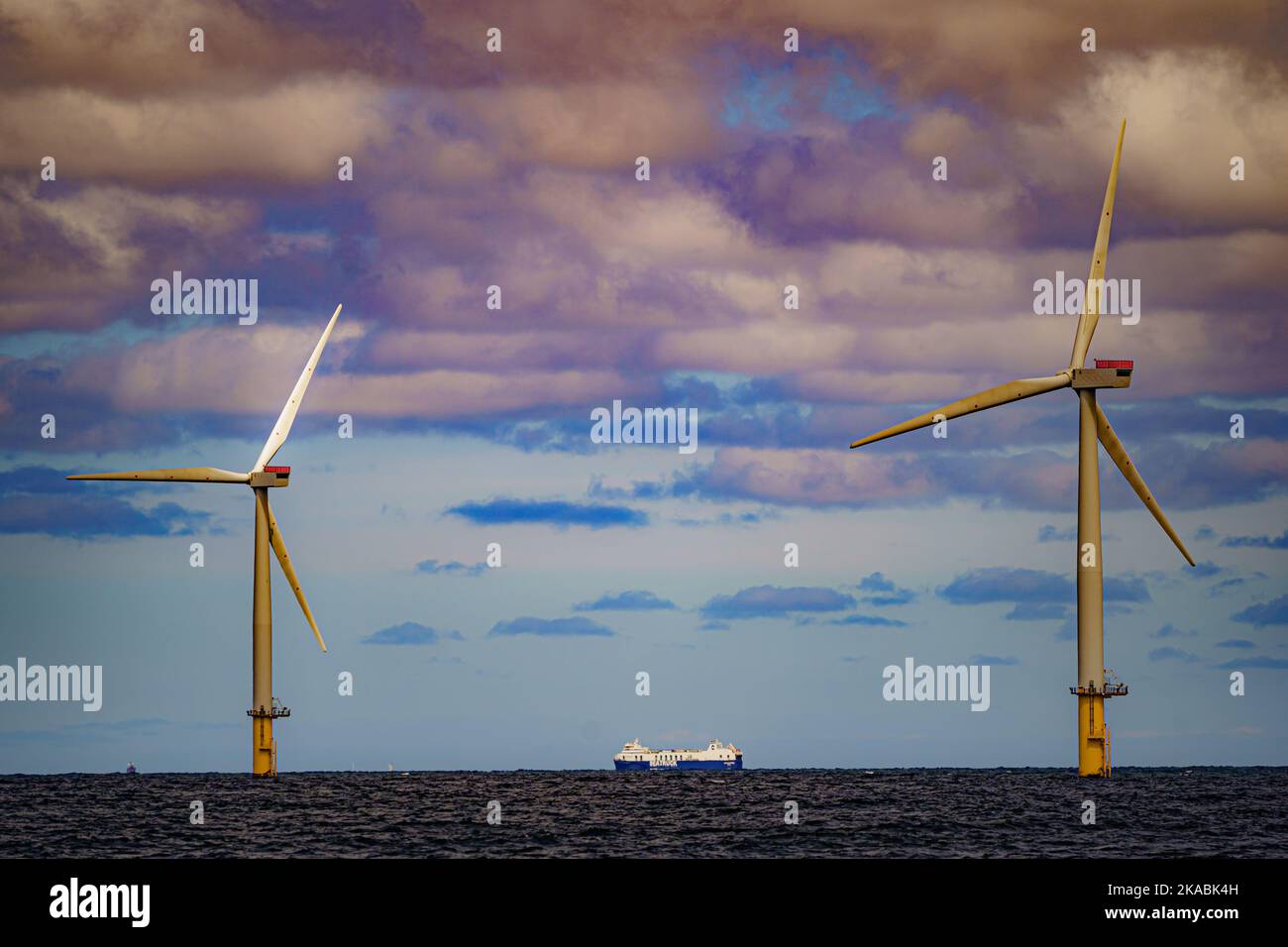 Foto del file datata 26/07/22 di una nave che passa per turbine eoliche presso Gwynt y Mor di RWE, mentre i dati chiave del settore dell'energia offshore si riuniranno ad Aberdeen mercoledì per discutere lo sviluppo di competenze verdi tra la forza lavoro per una giusta transizione dai combustibili fossili. Foto Stock