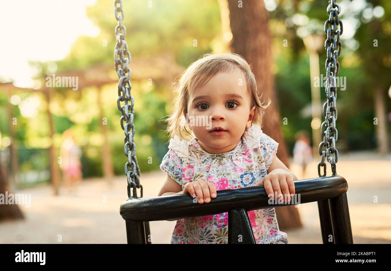 Divertimento in pieno swing. Bambina che gioca su un swing in un parco. Foto Stock